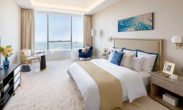 A modern bedroom with a scenic ocean view and cozy decor