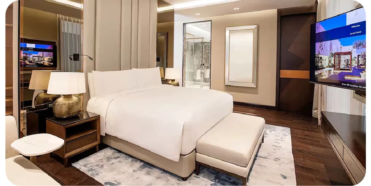 A modern hotel room with a bed and a TV