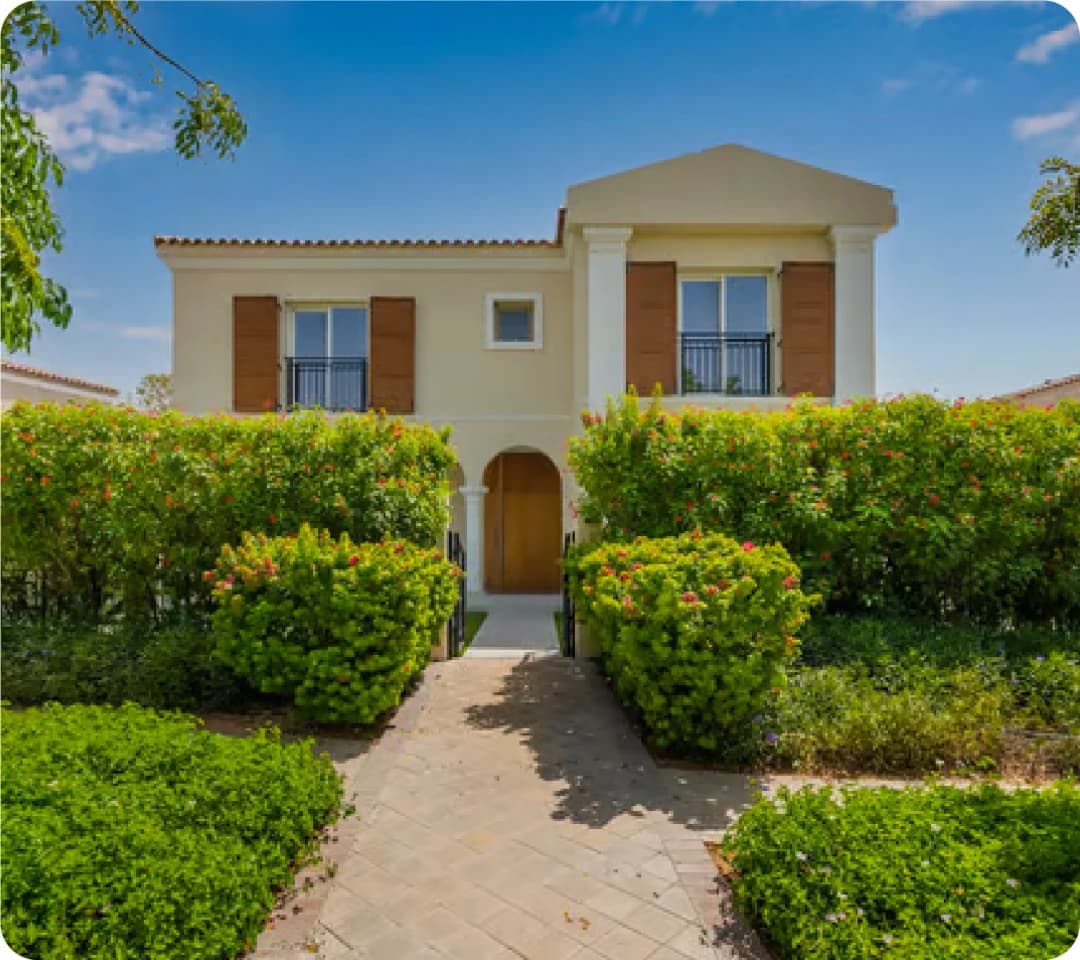 Front view of a beautiful villa with green landscaping