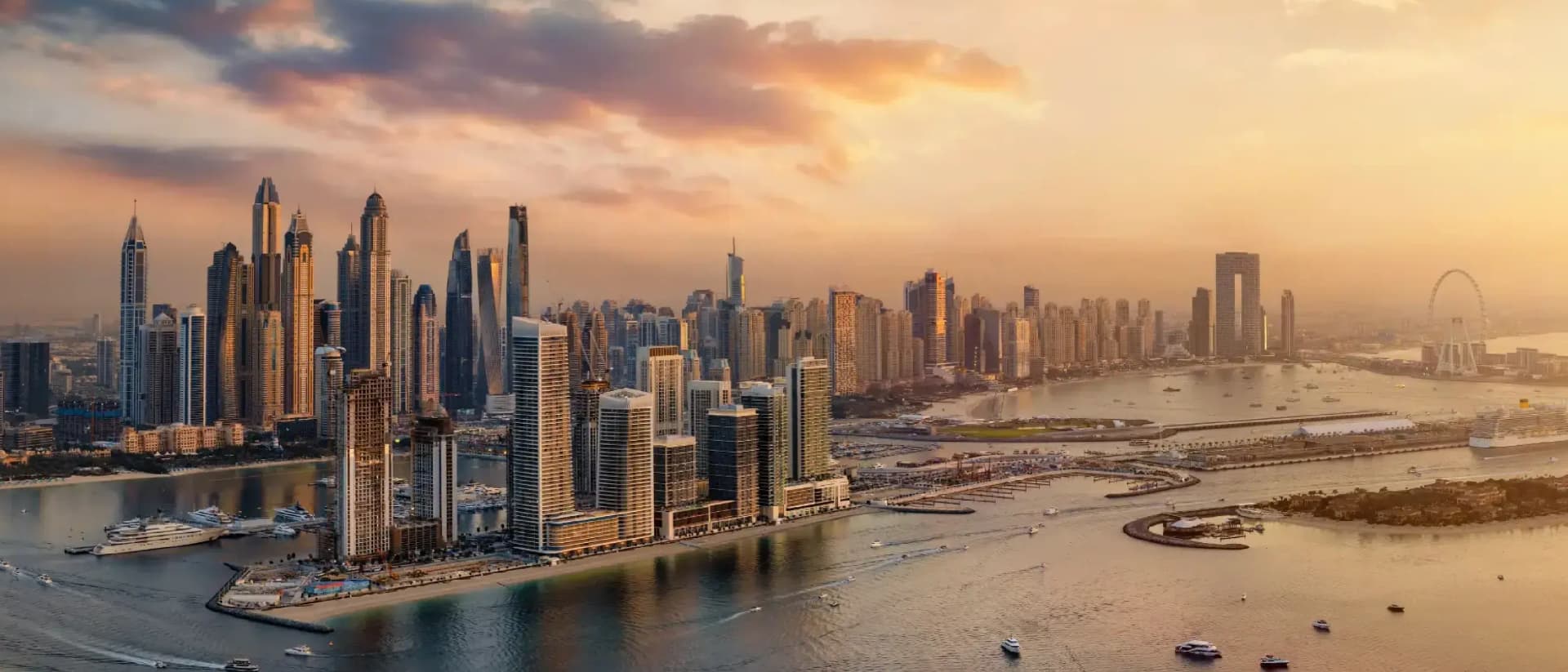 Dubai Marina skyline at sunset with boats in the water