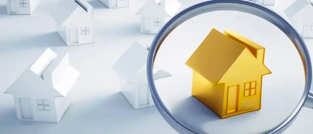 Golden house under a magnifying glass among white houses