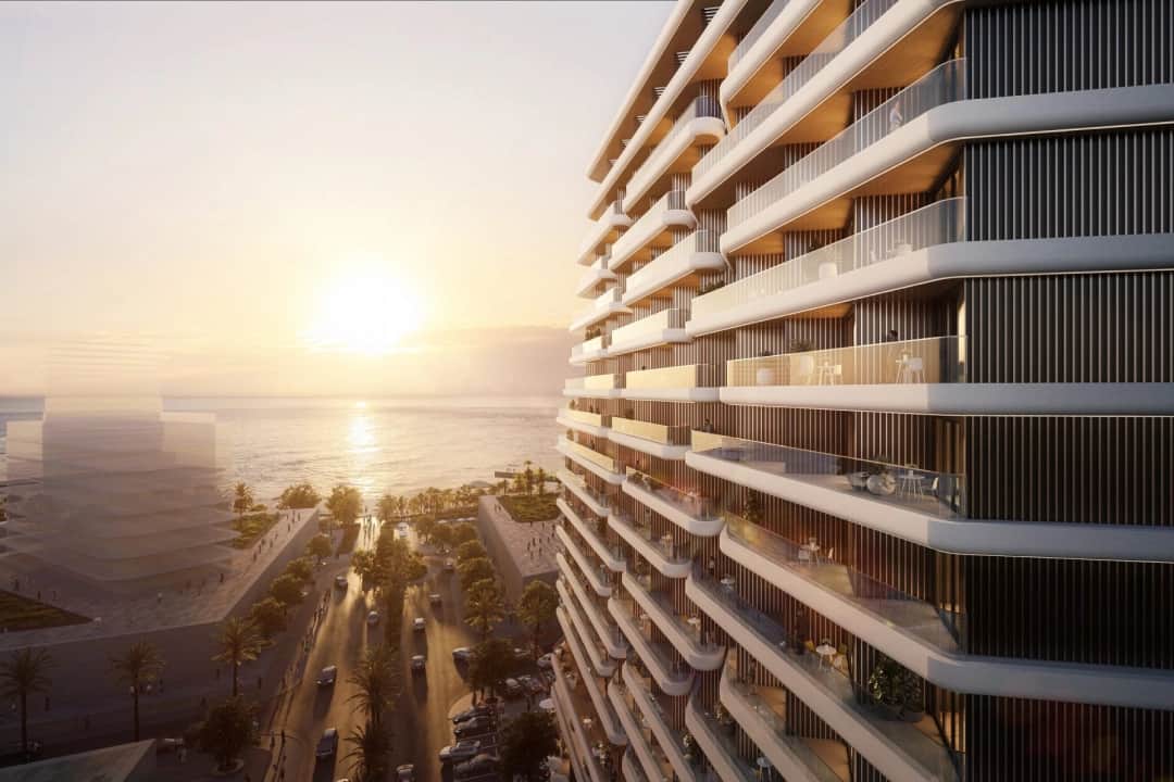 Sunset view of a sleek oceanfront building with modern design