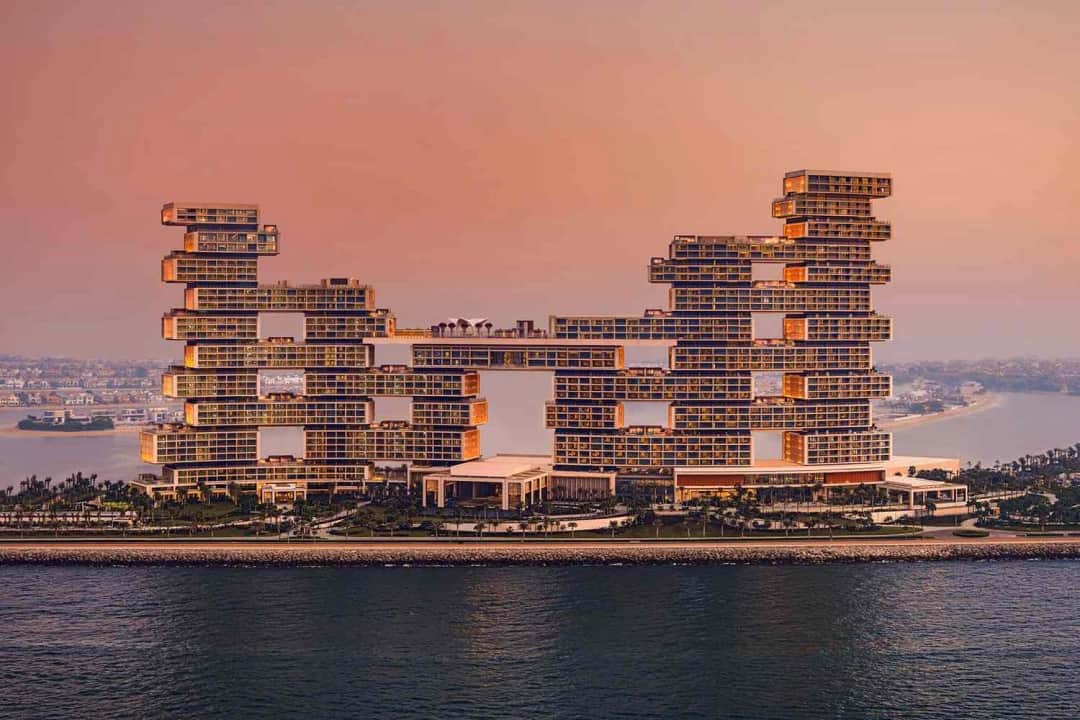 Modern stacked building overlooking the water at sunset