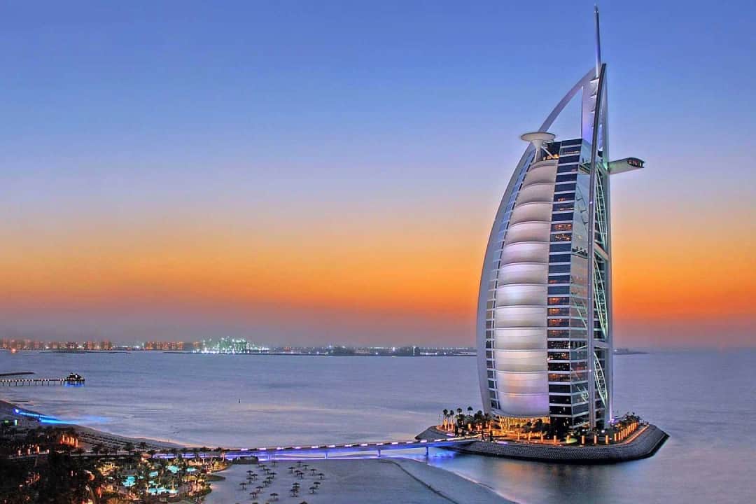 Night view of Burj Al Arab with vibrant lights and ocean view