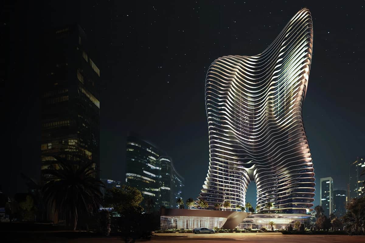 Futuristic, wavy skyscraper illuminated at night