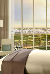 A cozy bed with TV and golf view from window at Golf views at Emaar