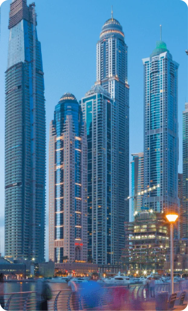 High-rise buildings and promenade at Dubai Marina during twilight.