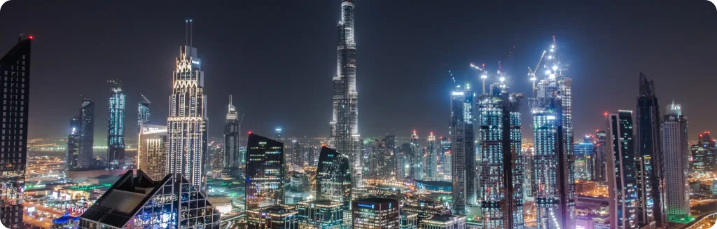 Dubai's iconic skyline at night, featuring the Burj Khalifa and illuminated skyscrapers showcasing the city's modern architecture.