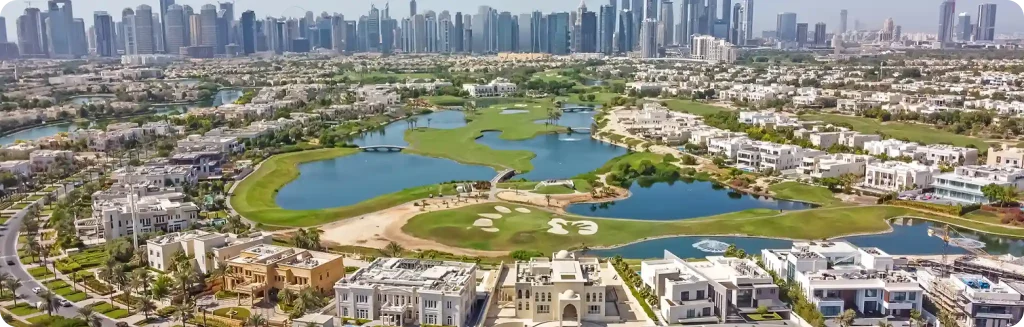 Aerial view of a luxurious residential community with villas, lush green golf courses, serene lakes, and Dubai's skyline in the background.