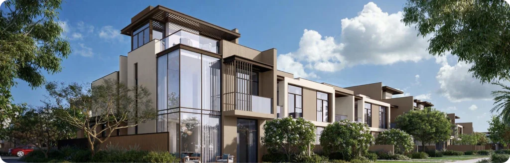 Modern luxury villas with sleek architecture, large glass windows, and lush greenery under a bright blue sky.